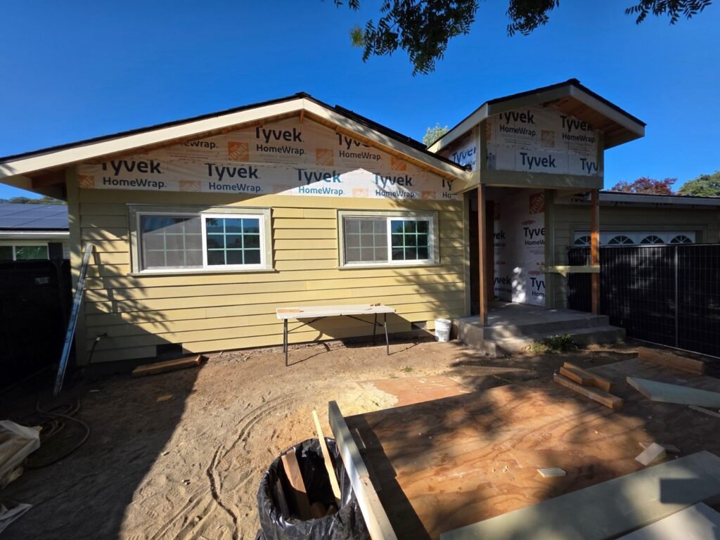 Home addition with house wrap on the gables and new lap siding installed below