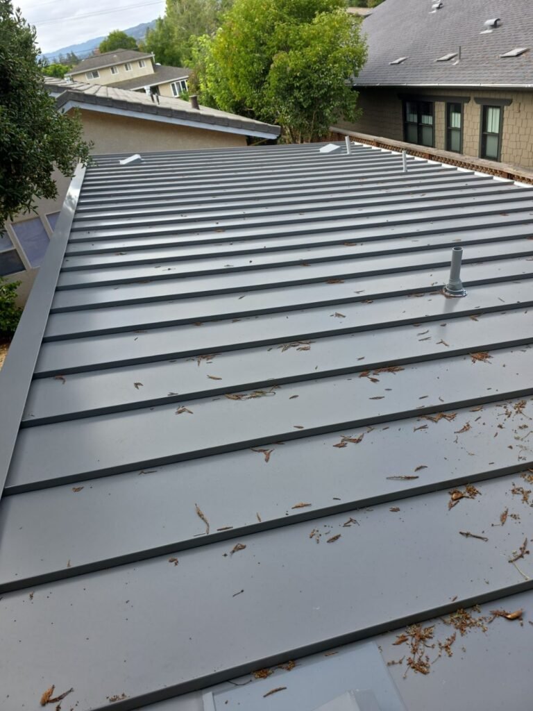 Standing-seam metal roof panels with a sealed pipe vent penetration