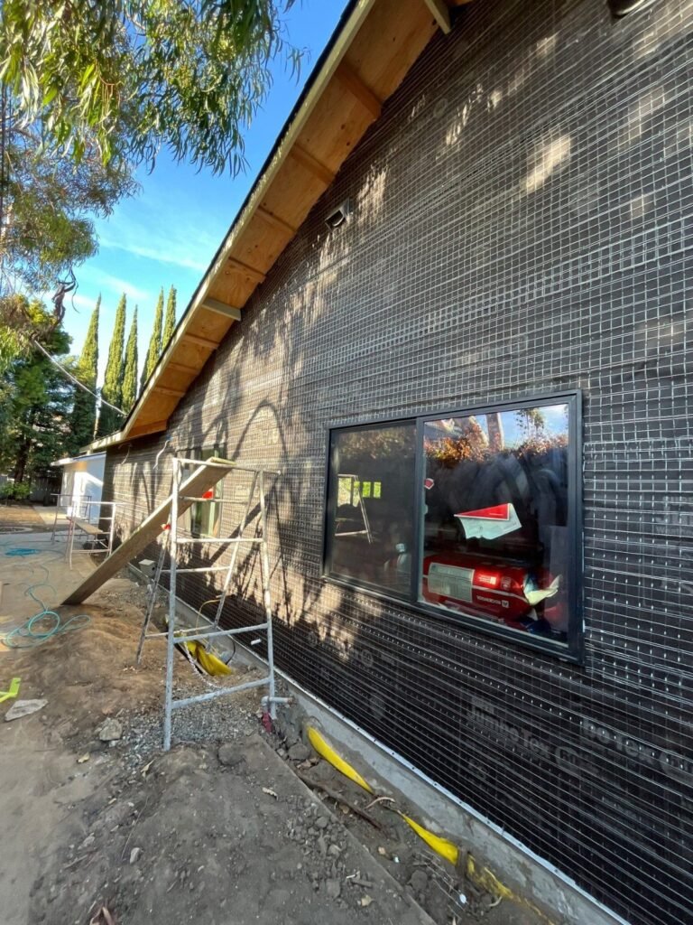 Building paper and wire lath with a weep screed at the base of the wall, ready for stucco