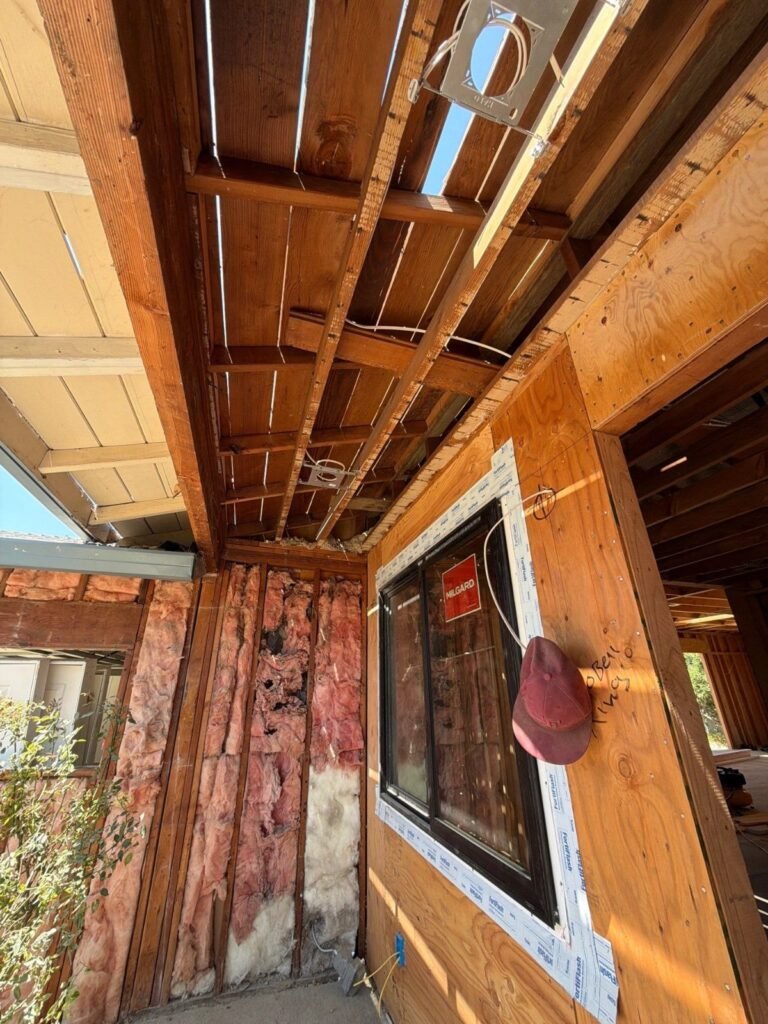 Self-adhered flashing tape sealing a new window flange to the wall sheathing